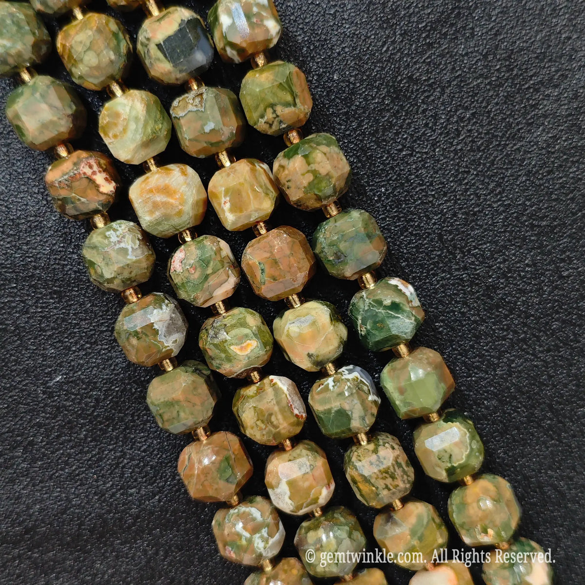 Multiple parallel strands of natural bird egg jasper soft-tumbled cube beads viewed from distance