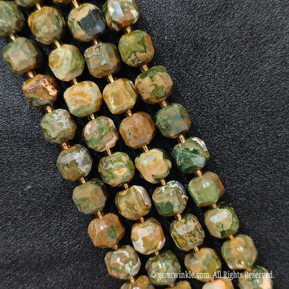Multiple parallel strands of natural bird egg jasper soft-tumbled cube beads viewed from distance