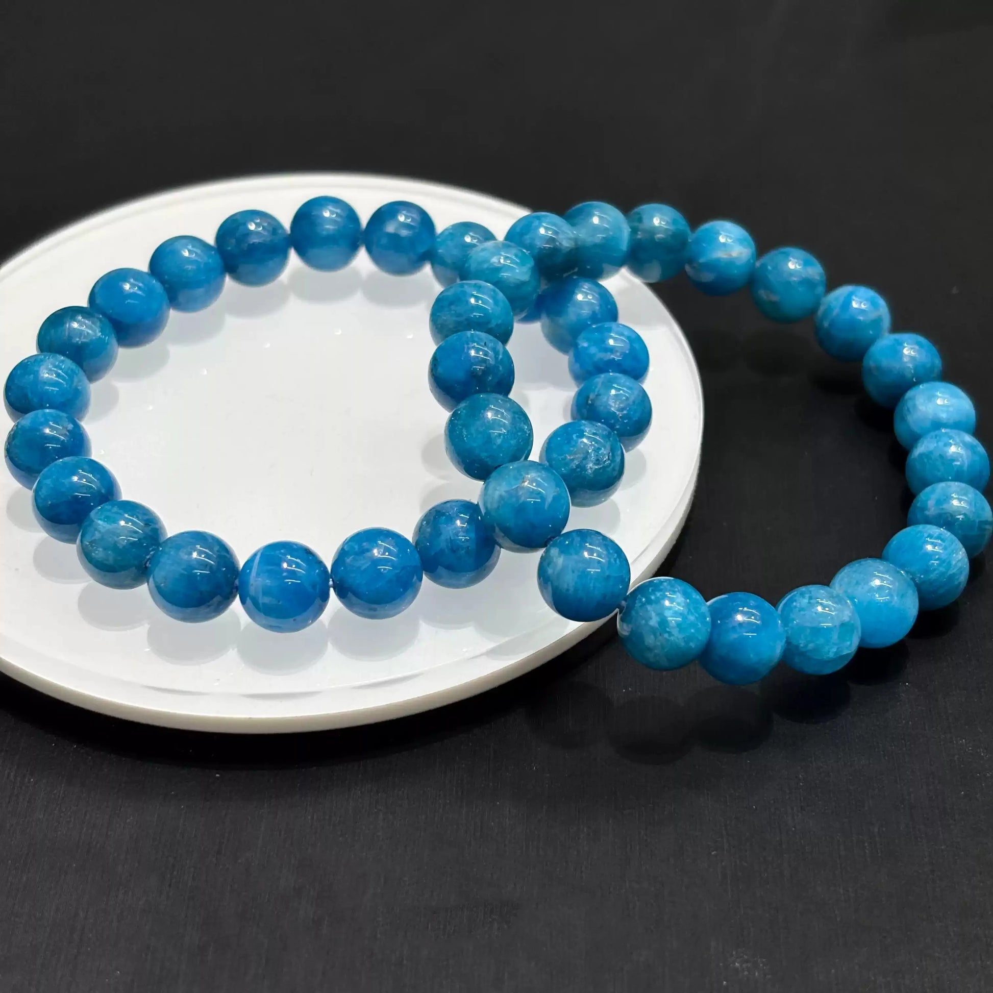 Collage of blue apatite bracelet worn on wrist in 4 settings: raised hand, side profile, close-up pose, street view — all on same model