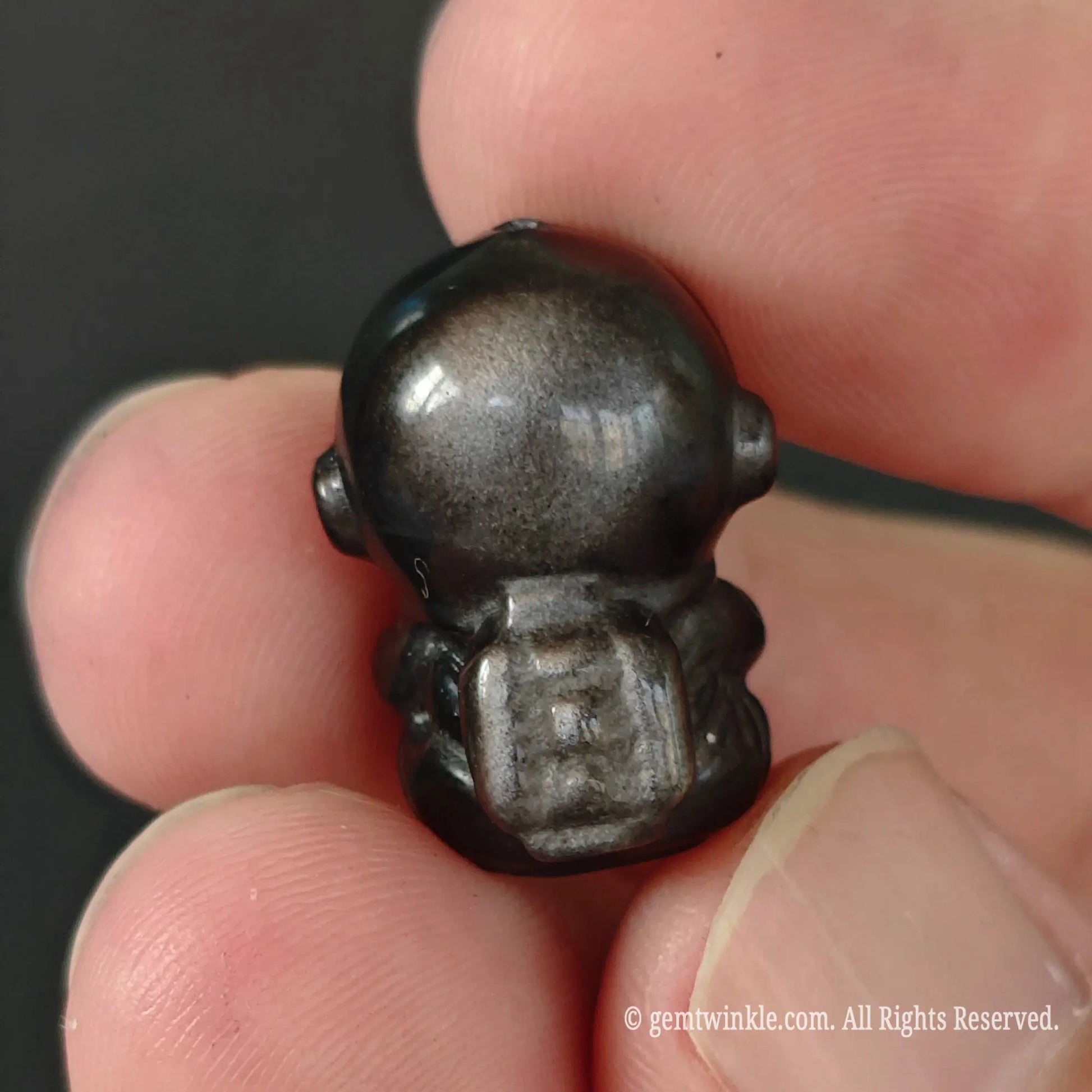 20mm silver sheen obsidian astronaut bead back view showing carved backpack detail and glossy metallic reflection