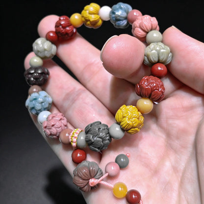 Close up view of a natural multi color Alxa agate lotus carved bead bracelet showing detailed flower petal carvings