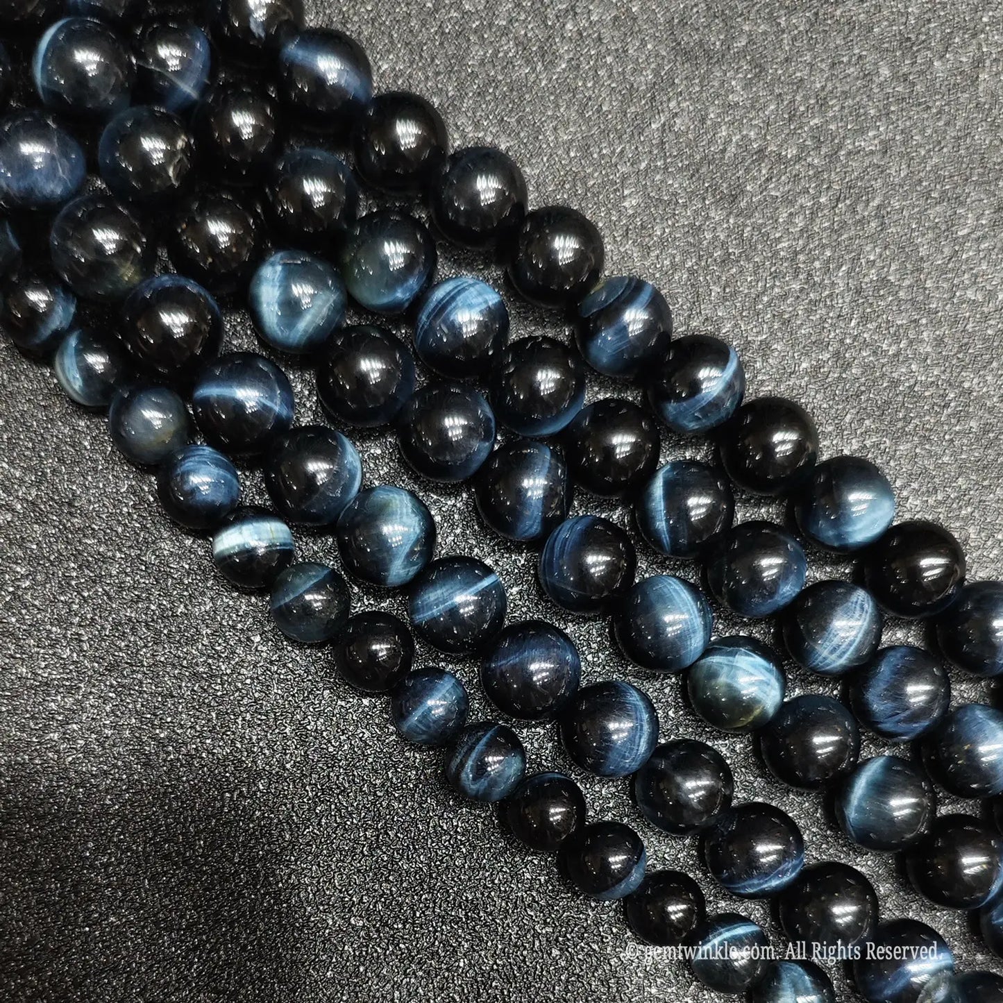 Polished blue tigers eye loose gemstone strands showing natural silky mineral fibers