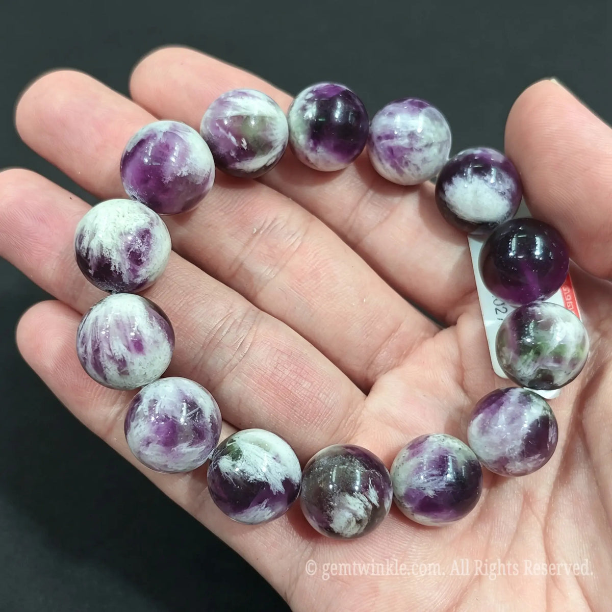 Detailed shot of oversized natural feather fluorite beads demonstrating internal misty veils and heavy polish