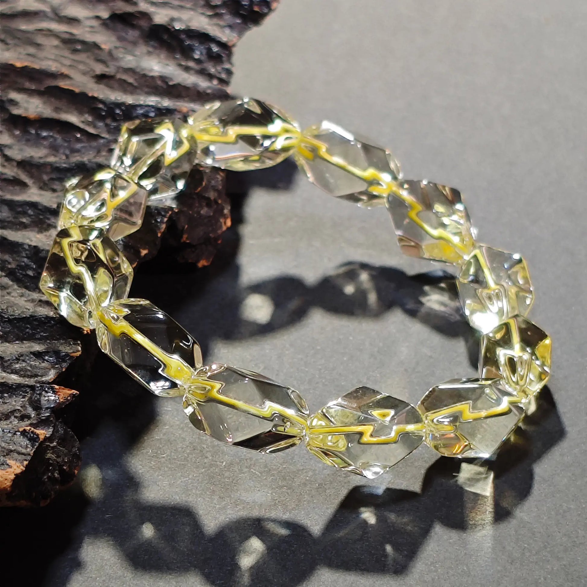 Lemon yellow citrine bracelet on dark stone surface—highlighting geometric facets and luminous color depth
