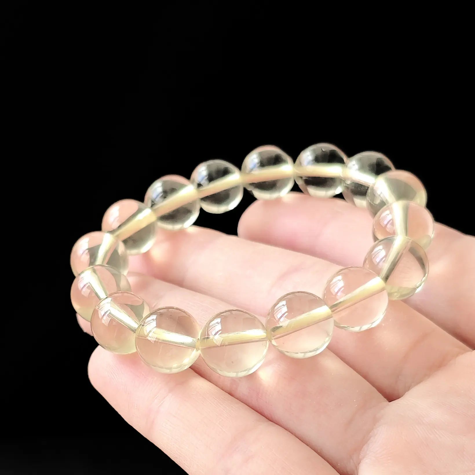 Women’s citrine round bead bracelet held flat—showing consistent size, soft yellow tone, and smooth polish