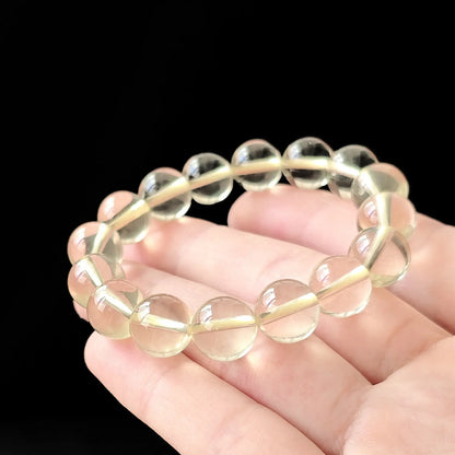 Women’s citrine round bead bracelet held flat—showing consistent size, soft yellow tone, and smooth polish