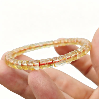 Close-up of mini citrine tablet bracelet held in hand—showing translucency and smooth polished edges