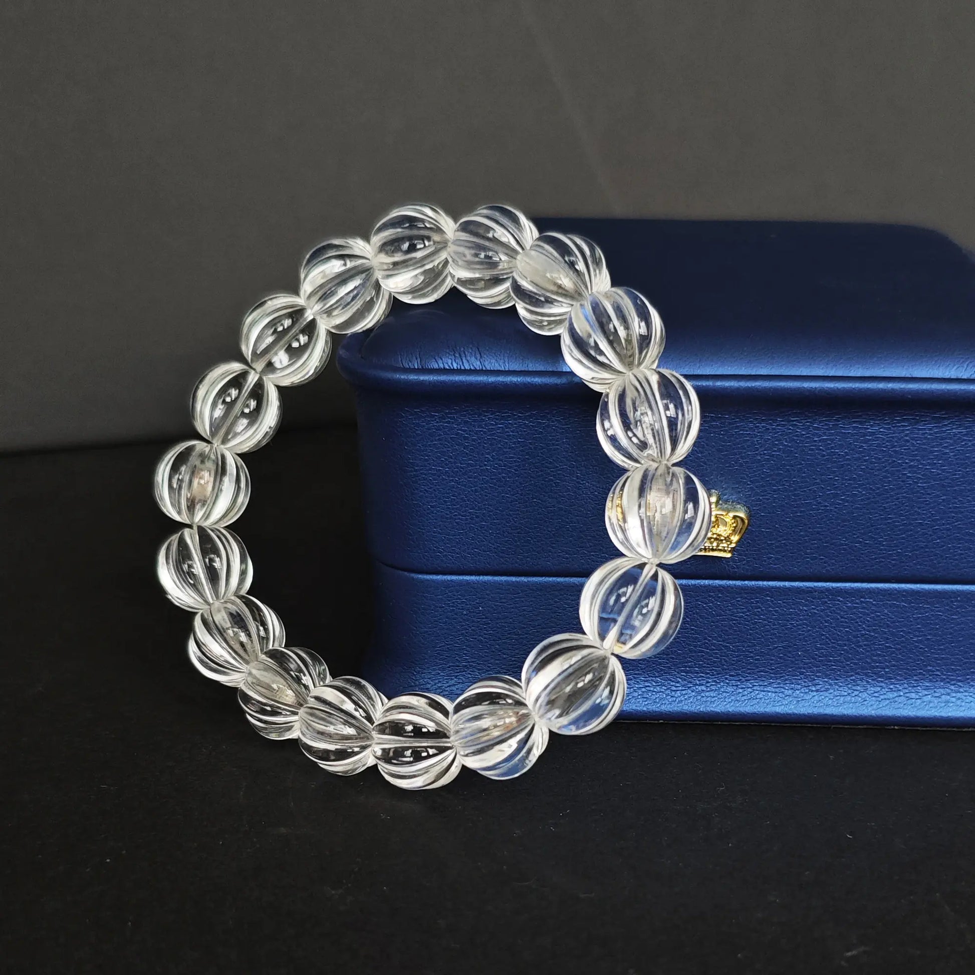 Clear quartz pumpkin bead bracelet resting beside a navy blue jewelry box with gold clasp, highlighting premium gifting presentation