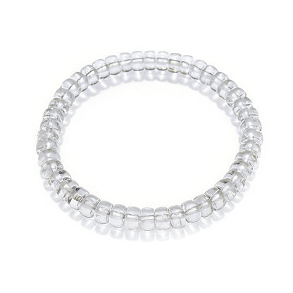 Transparent natural clear quartz disc bead stretch bracelet displayed on white background, smooth polished surface, no clasp