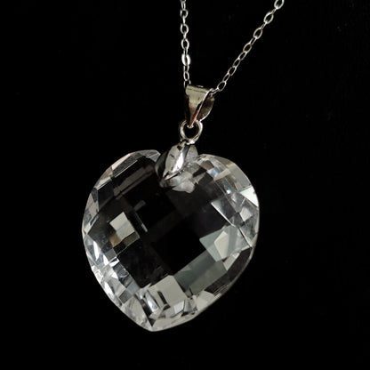 Natural clear quartz heart-shaped pendant with S925 silver chain, displayed flat on black background, showcasing geometric facets and transparent clarity