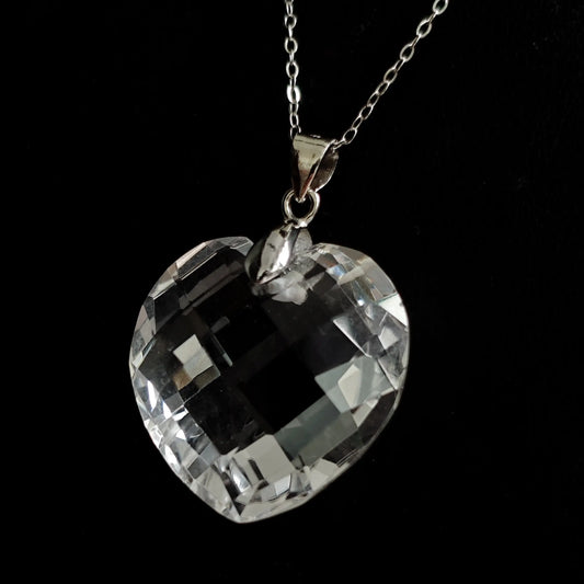 Natural clear quartz heart-shaped pendant with S925 silver chain, displayed flat on black background, showcasing geometric facets and transparent clarity