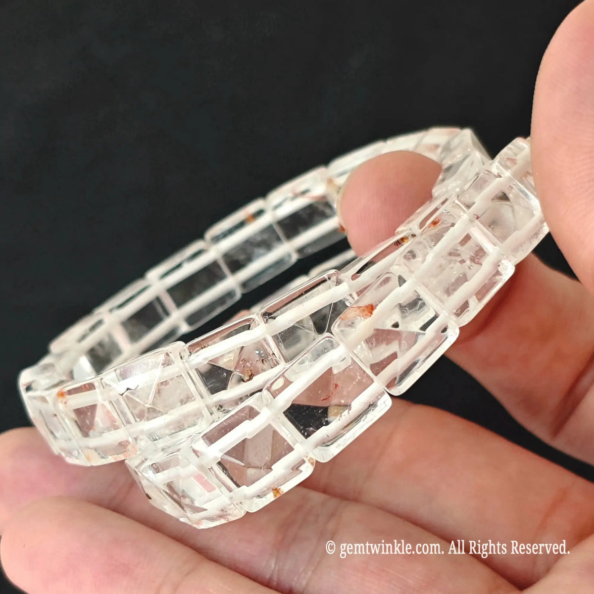 Side view of a natural clear quartz pyramid tile stretch bracelet showing light reflecting facets and double row elastic construction