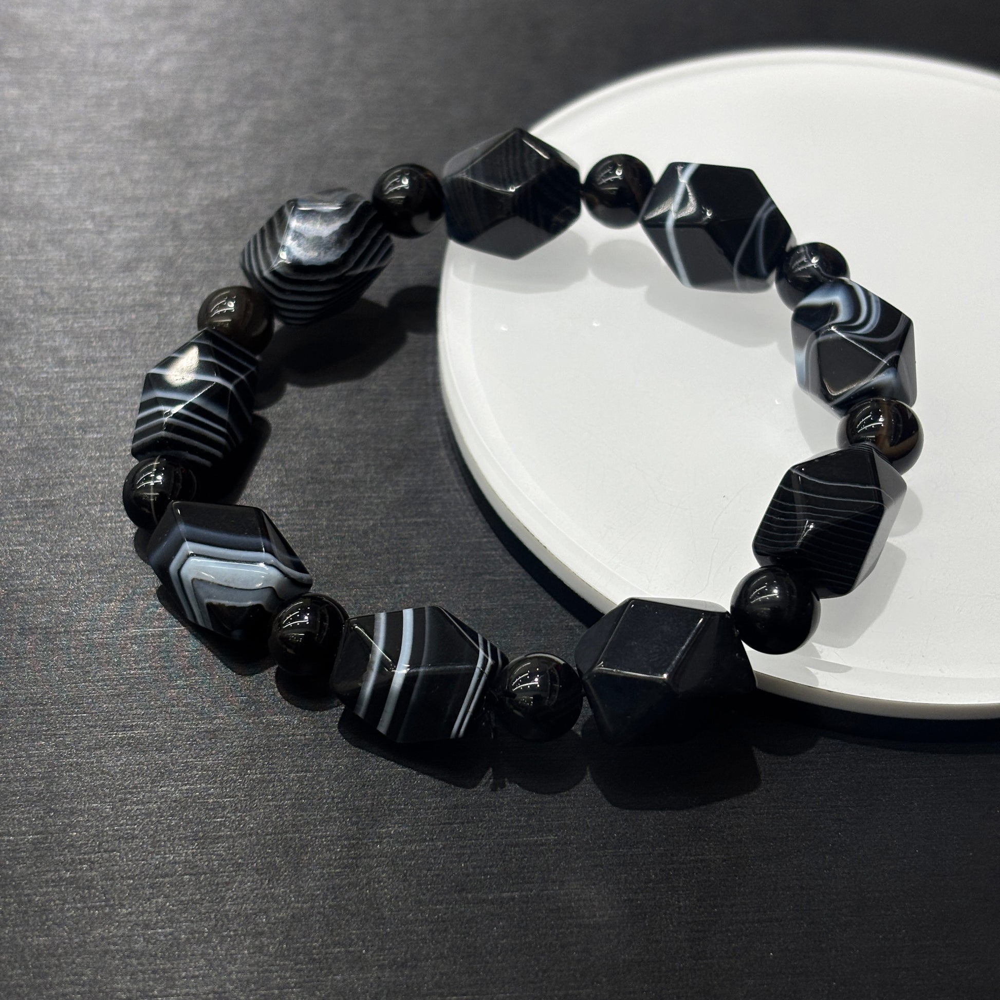 Close-up of natural banded agate irregular geometric beads with white-black stripes, hand-polished surfaces