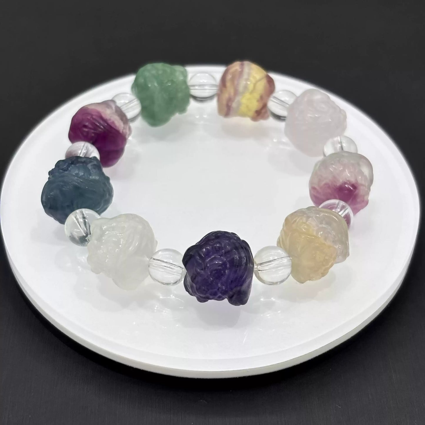 Detailed view of hand-carved fluorite lion head bead: smooth surface, translucent quality, and symbolic facial features