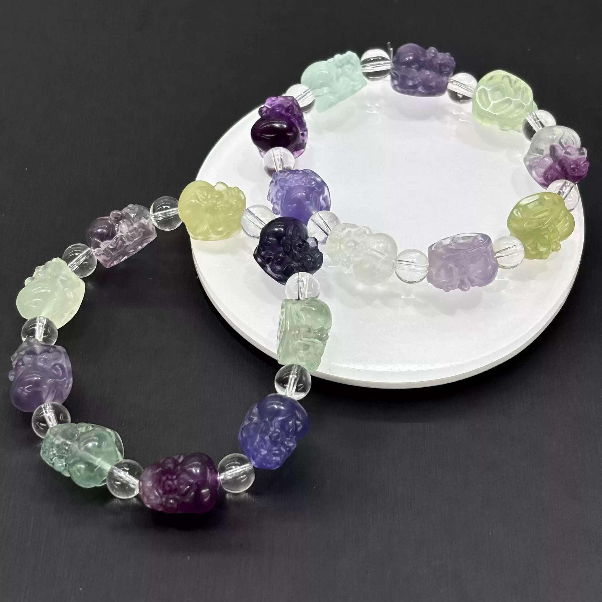 Detailed view of hand-carved fluorite Pi Xiu bead: translucent quality, symbolic form, and polished surface