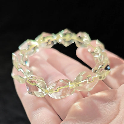 Detailed view: precisely faceted citrine bead with smooth polish, lemon-yellow hue, and minimal internal texture