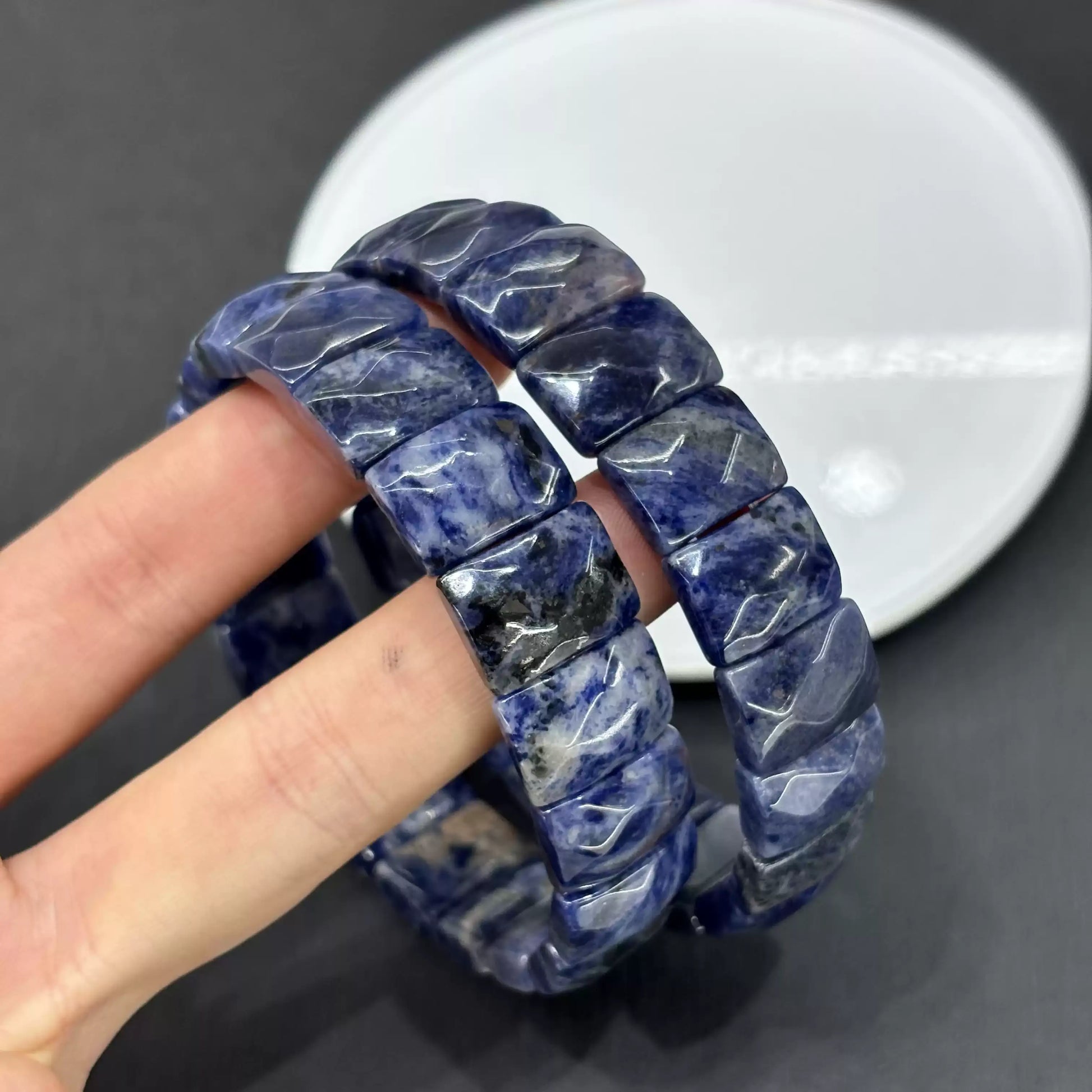 Detailed view of natural sodalite’s blue base with white calcite or feldspar inclusions; faceted edges catch light beautifully