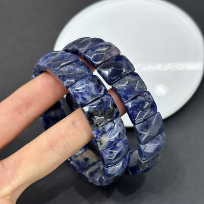 Detailed view of natural sodalite’s blue base with white calcite or feldspar inclusions; faceted edges catch light beautifully