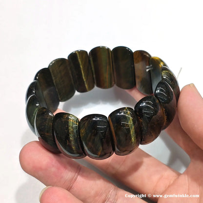 Side view of tiger eye bracelet showing 25mm bead length, precise alignment, and natural color banding (red/yellow/blue/black) for retail display