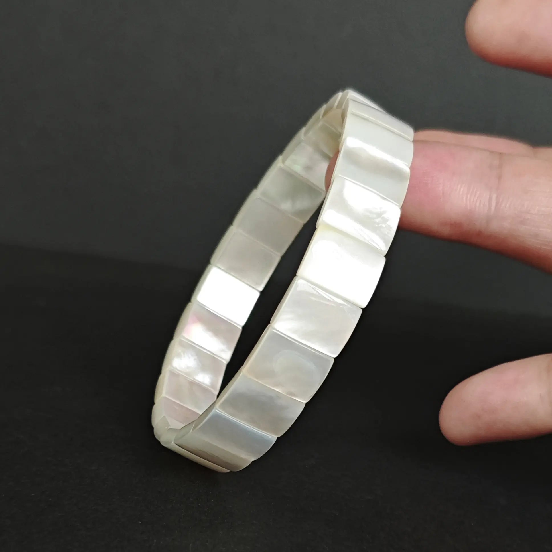 Close-up of white mother-of-pearl rectangular beads highlighting smooth faceted edges and subtle nacreous glow