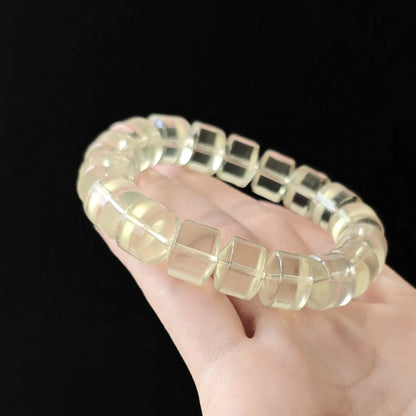 Macro view: single lemon-yellow citrine wheel bead with smooth beveled edges, no inclusions, high clarity under studio light
