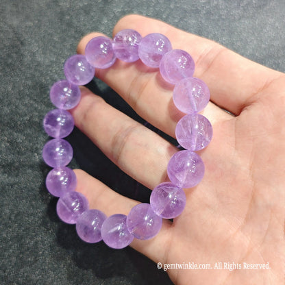 Full circle view of a soft lilac quartz stretch wristlet displayed on hand showing pastel purple tone[cite: 9]