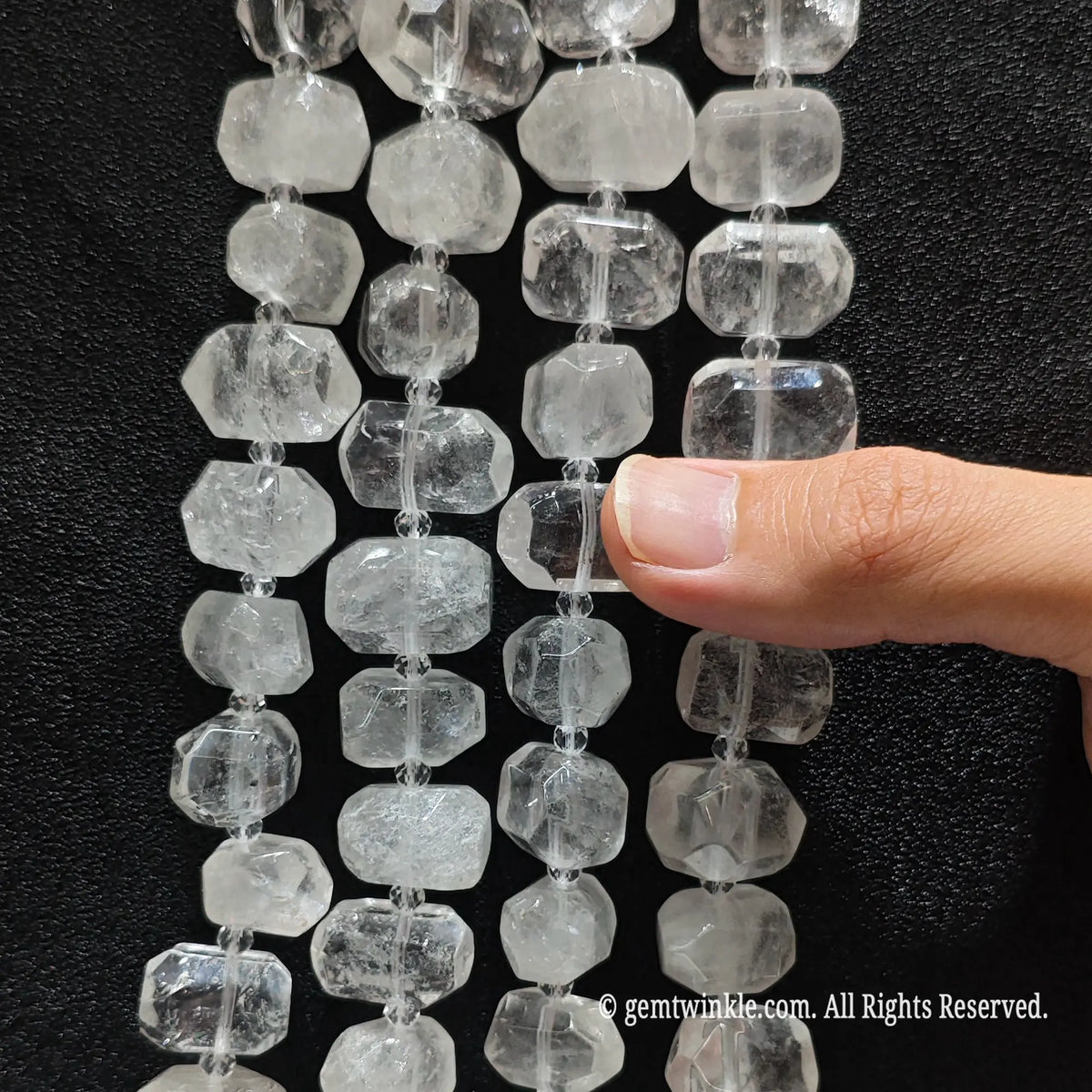 Side view of natural milky white quartz pebble beads strung on loose strands showing internal ice veils