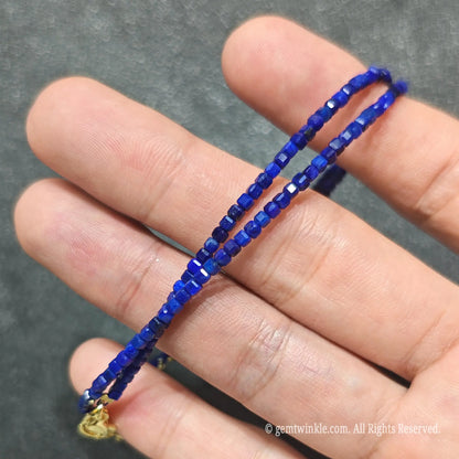 Detailed macro view of 2.5mm square cube Lapis Lazuli beads showing ultramarine blue stone with pyrite flecks