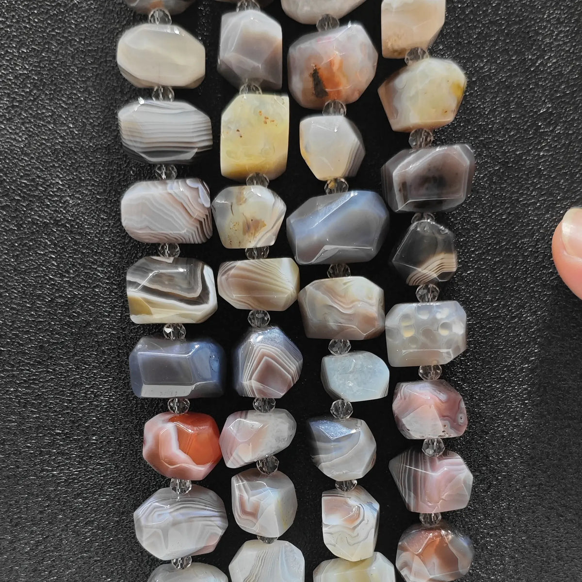 Strands of natural crazy lace agate rough faceted nugget beads displaying multi color concentric bandings for DIY jewelry making