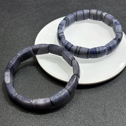 Blue aventurine square tablet bracelets crossed on dark surface, showcasing depth, transparency, and sparkle