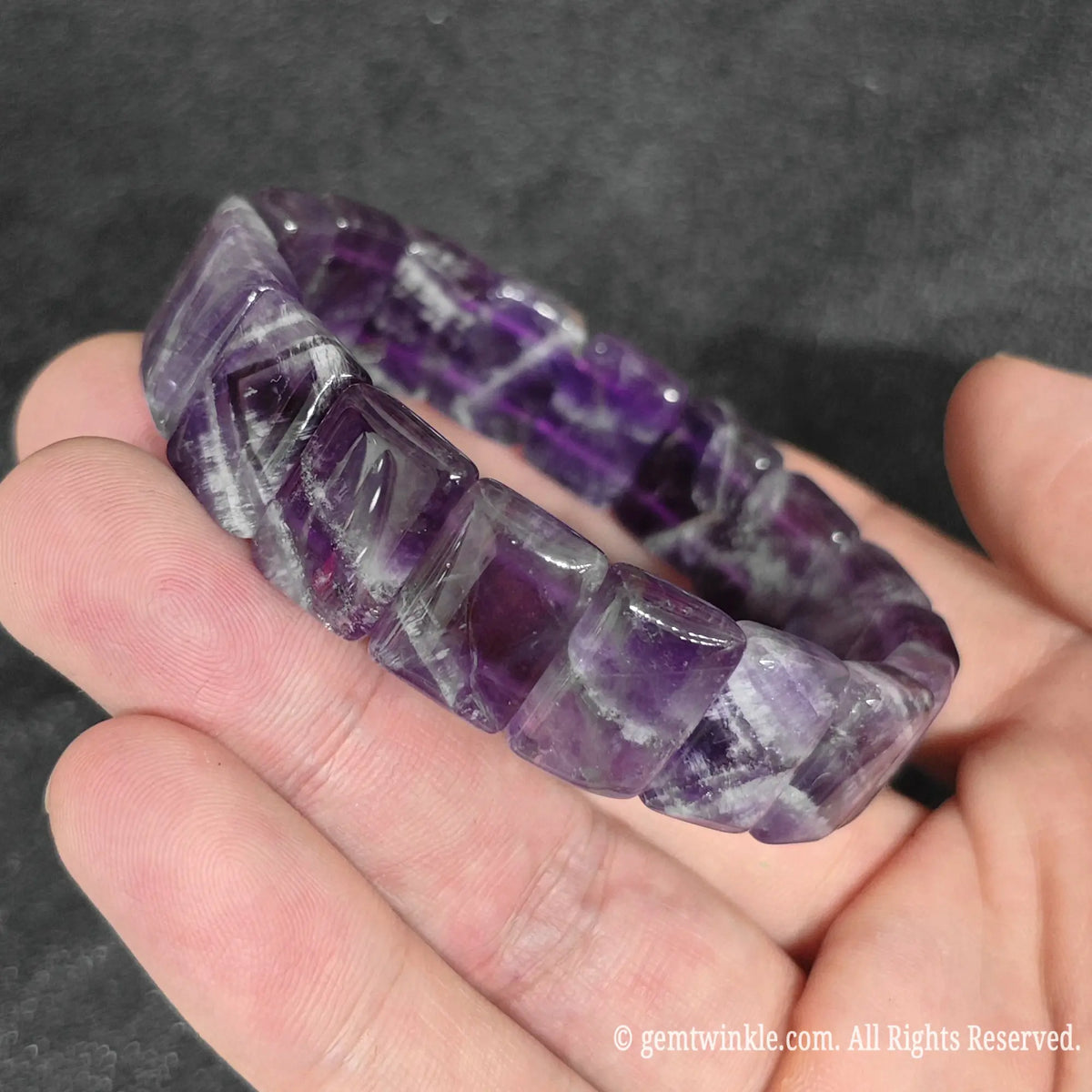Side view of a natural dark velvet chevron amethyst smooth block stretch bracelet showing vitreous polish and double row elastic construction