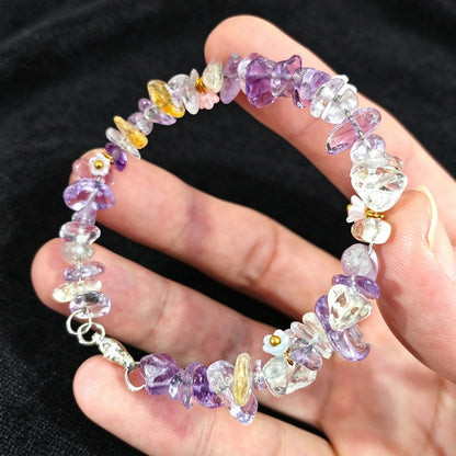 Hand displaying a delicate amethyst and citrine chip stone wire bracelet with metal clasp closure