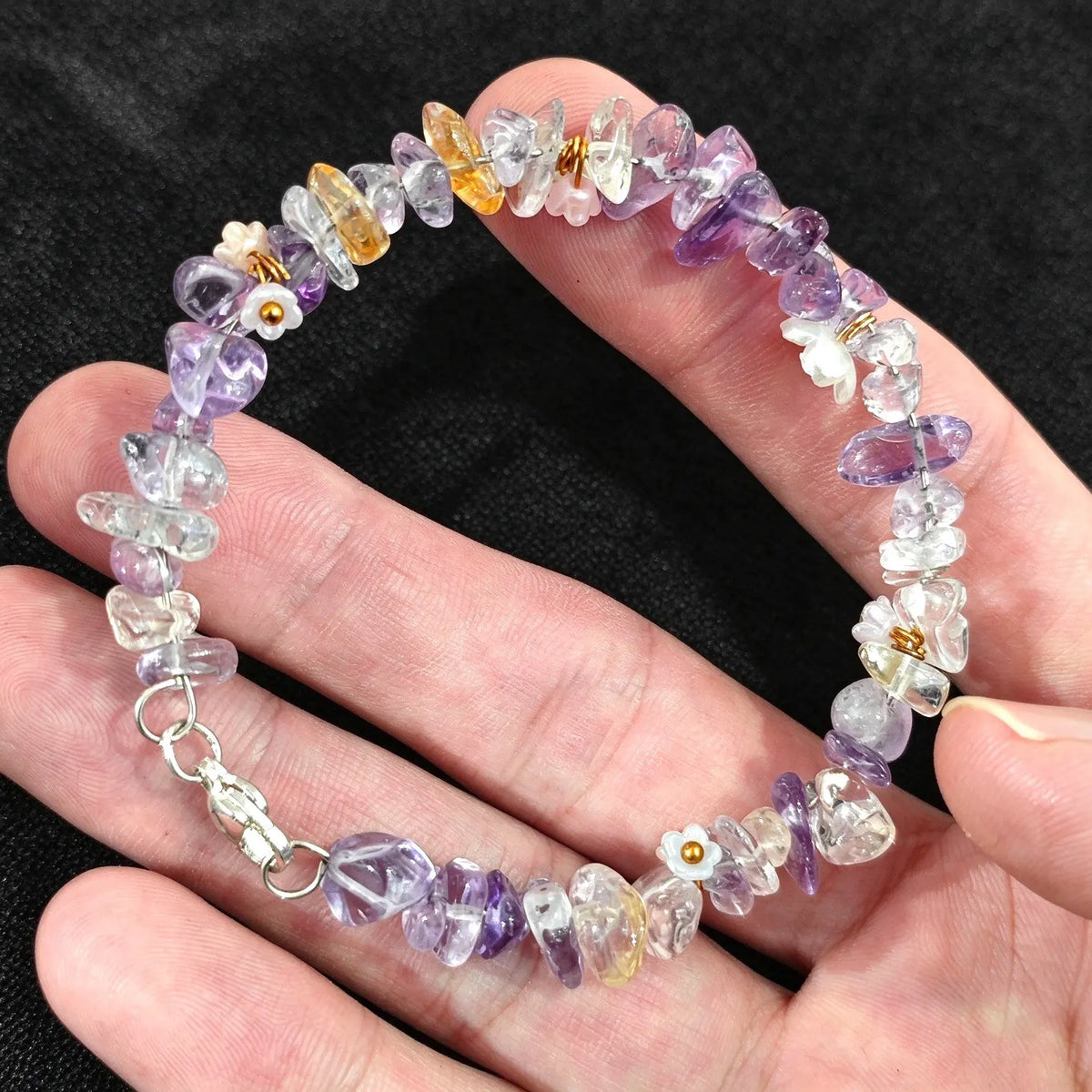 Close up view of metal lobster clasp and wire structure on amethyst citrine chip stone bracelet