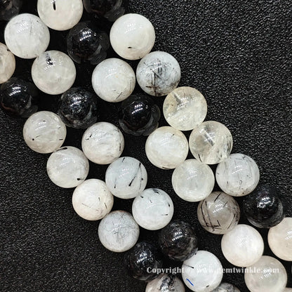Detailed shot of real economy C grade black tourmaline quartz beads with heavy cloud textures and ice cracks strung on jewelry cords