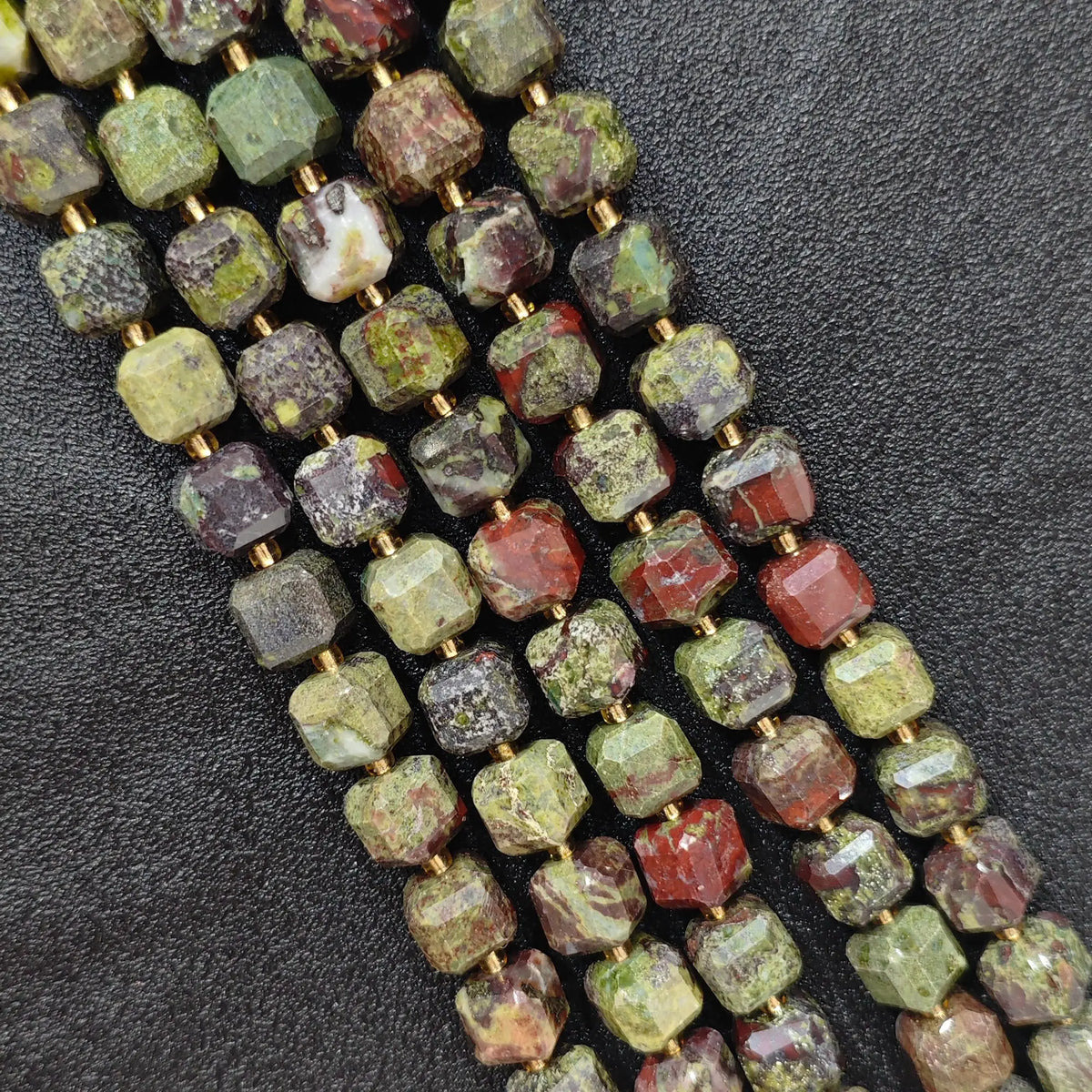 Close up of multi strands of natural dragon blood jasper soft-tumbled geometric cube beads showing overall strand layout