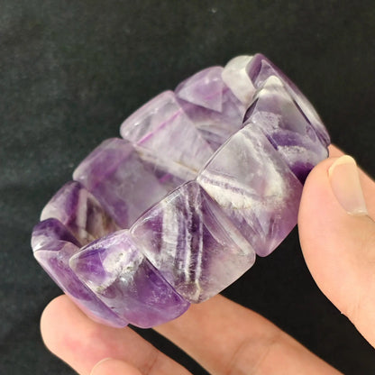 Natural dreamy chevron amethyst smooth bamboo segment stretch bracelet held on hand displaying purple and white chevron bands