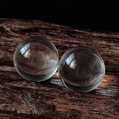 Two natural clear quartz spheres (approx. 2cm) on resin base, demonstrating near-inclusion-free transparency and smooth polish; minimalist spiritual decor