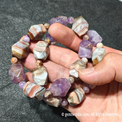 Close up view of stacked amethyst and banded agate faceted nugget bracelets highlighting unique striped agate textures