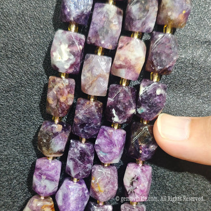 Close up view of natural royal violet lepidolite faceted block beads highlighting light reflecting facets and silky mica luster