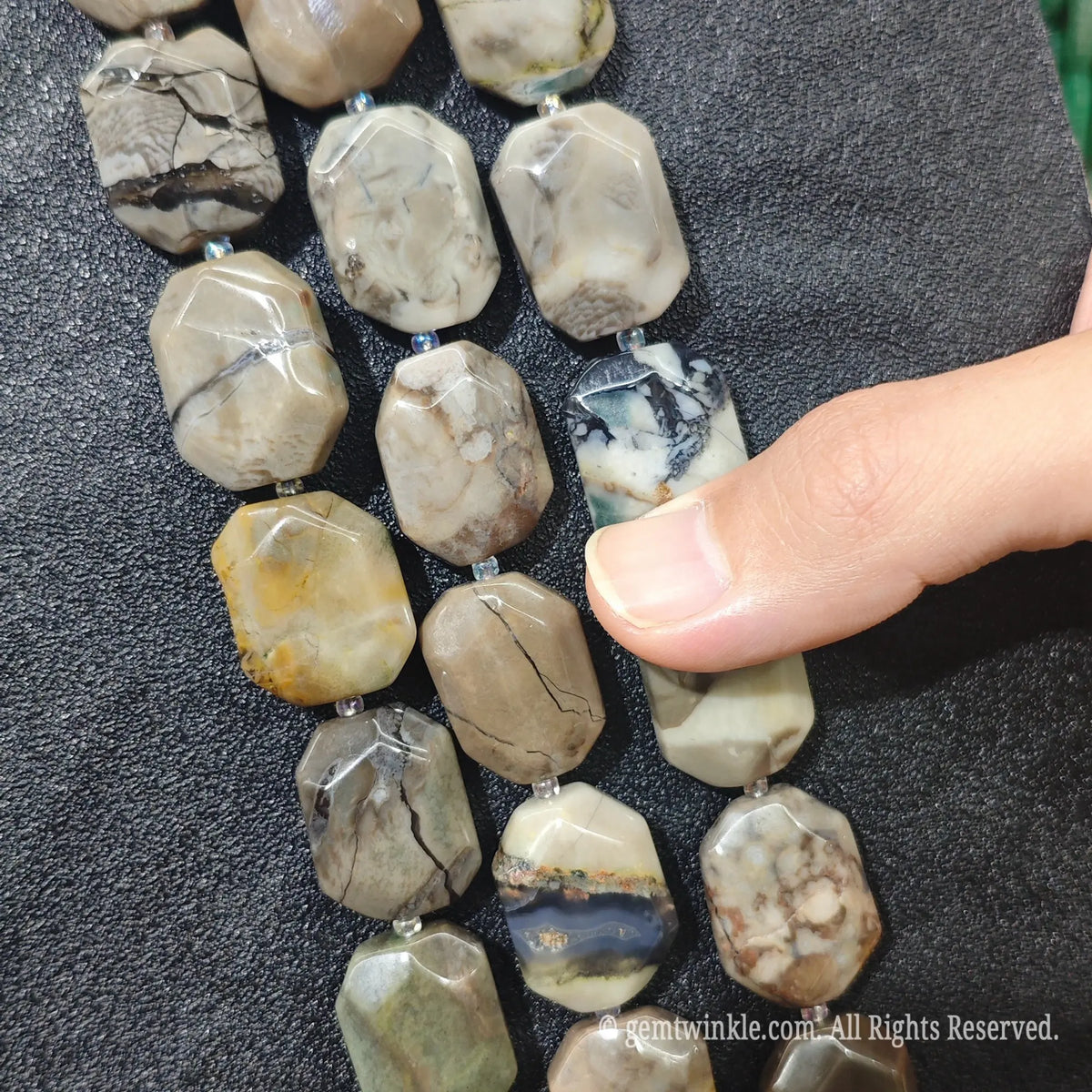 Close up view of natural volcanic ash agate faceted flat slab beads highlighting vein patterns and pre-drilled holes