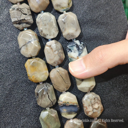 Close up view of natural volcanic ash agate faceted flat slab beads highlighting vein patterns and pre-drilled holes