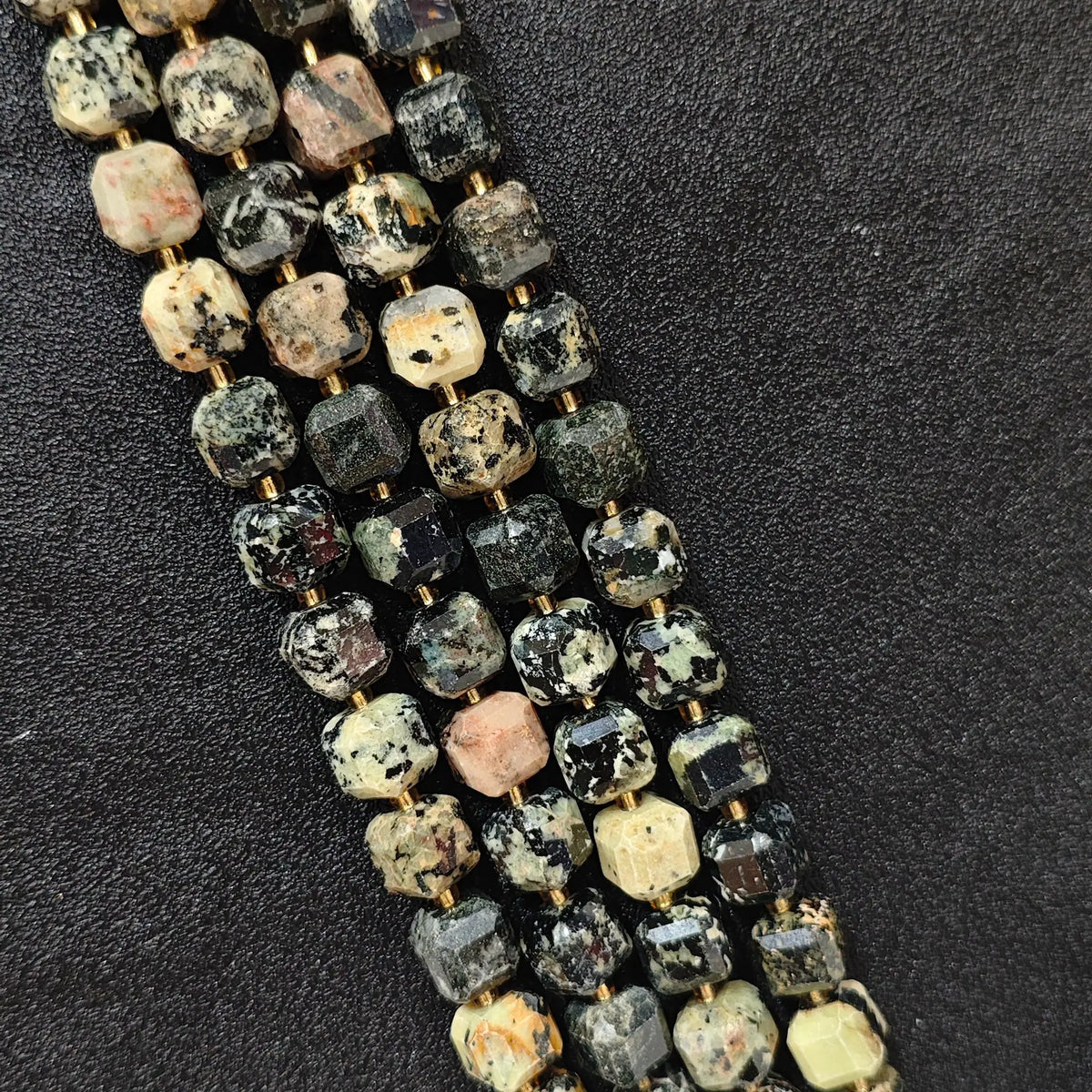 Close up of multi strands of natural fancy polychrome jasper soft-tumbled geometric cube beads showing overall strand layout