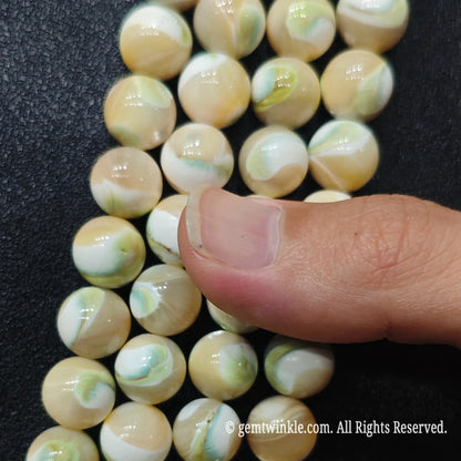 Close up view of green swirl shell round beads highlighting delicate natural spiral patterns and pearlescent sheen
