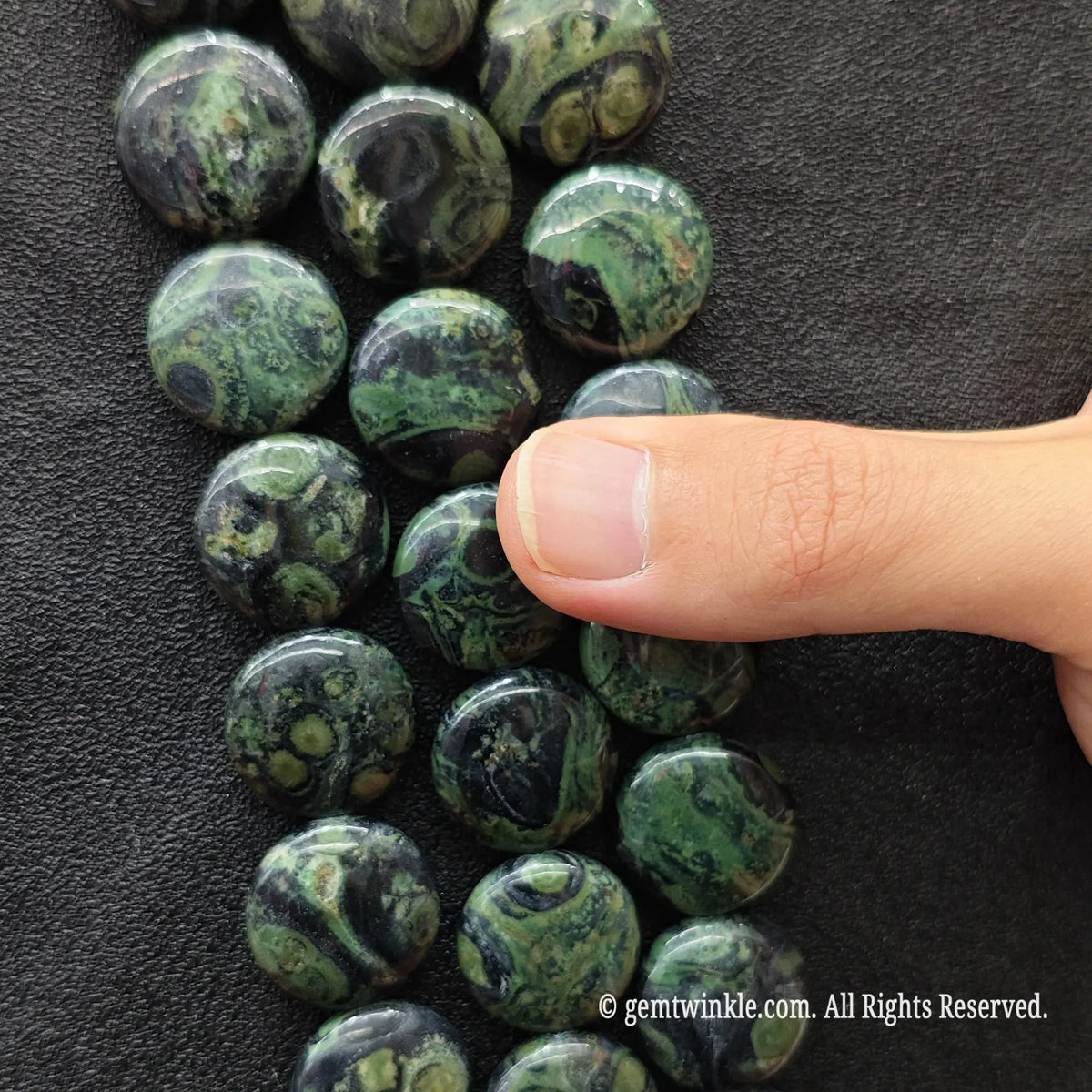 Natural peacock eye stone (Kambaba jasper) is a microcrystalline quartz/rhyolite mineral with a Mohs hardness of 6.5 to 7. To preserve the polished smooth finish of your flat coin beads, clean softly with warm soapy water and a soft microfiber cloth. Store loose strands separately to avoid scratching softer minerals.