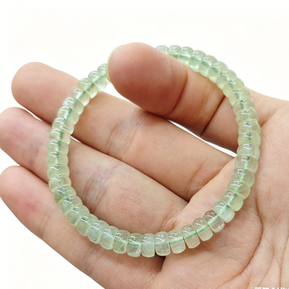 Mini prehnite tablet bracelet gently flexed to demonstrate elasticity and uniform bead alignment