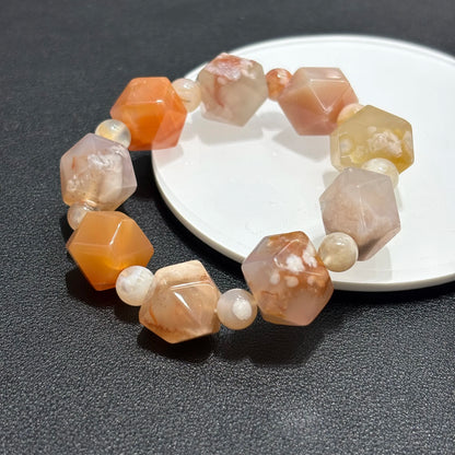 Lifestyle shot of Natural Flower Agate Cherry Blossom Pattern Bracelet worn with white fur coat, perfect for spring fashion and gifts