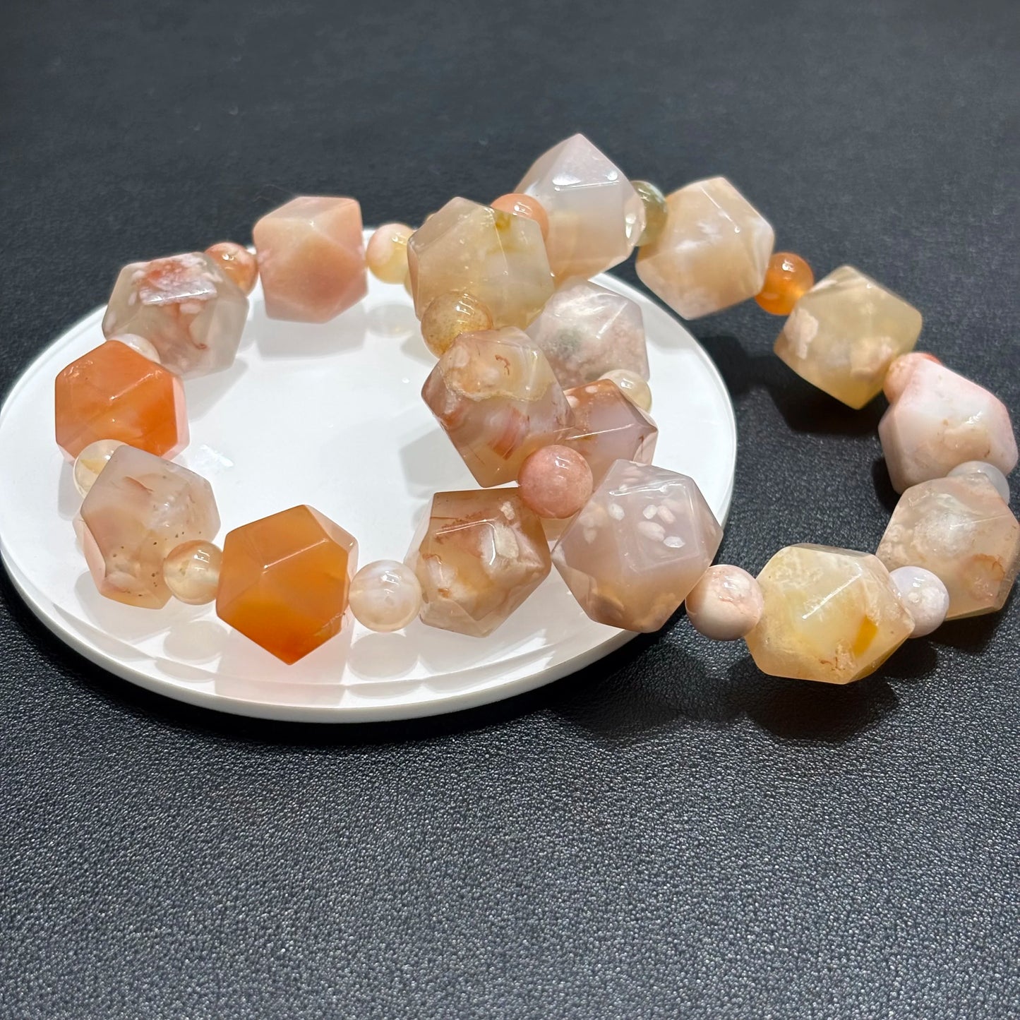 Top down view of Natural Flower Agate Cherry Blossom Pattern Bracelet on white plate, displaying the cherry blossom pattern and faceted beads