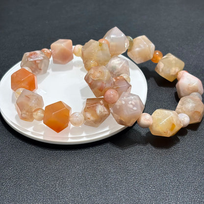 Top down view of Natural Flower Agate Cherry Blossom Pattern Bracelet on white plate, displaying the cherry blossom pattern and faceted beads