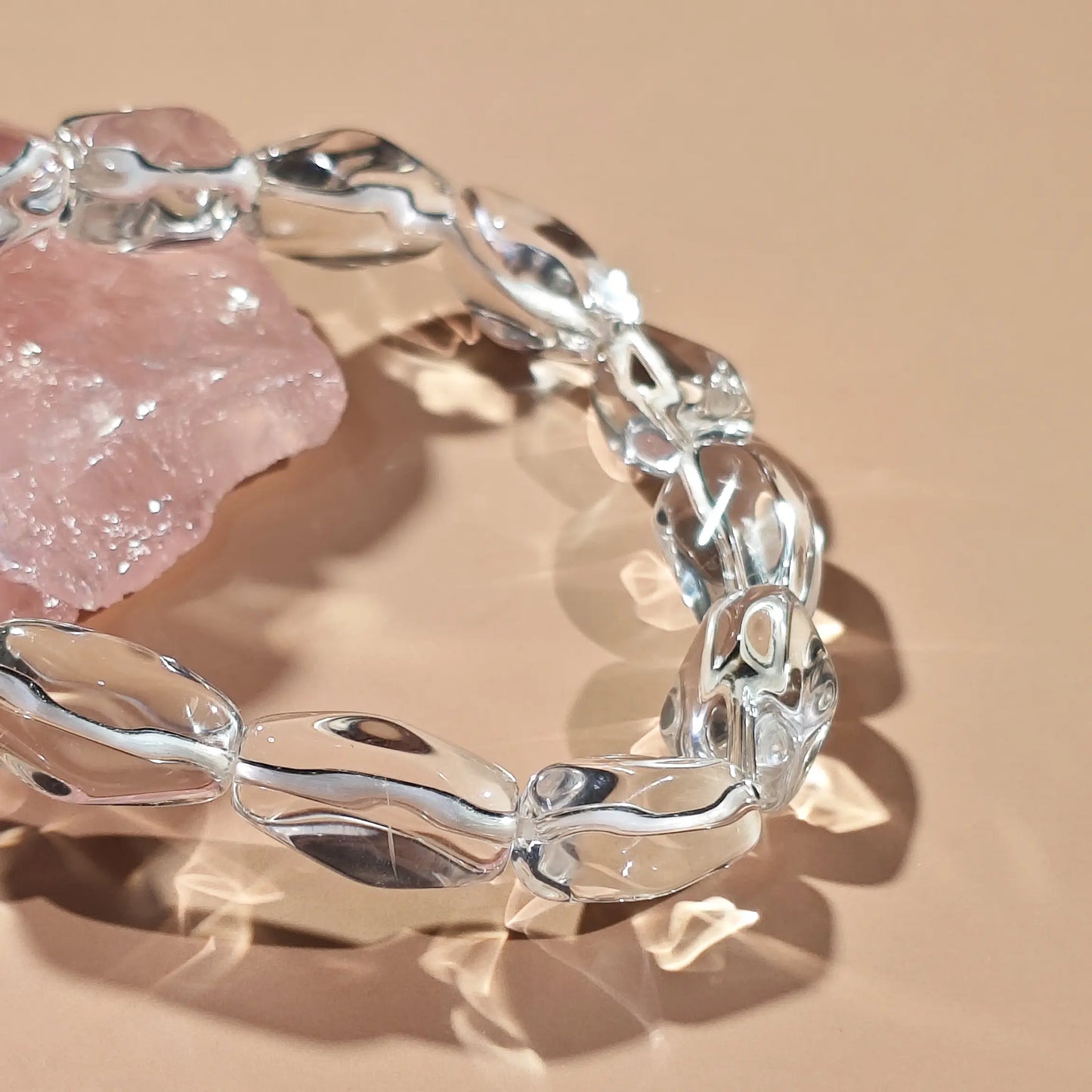 Clear quartz irregular beads arranged in infinity loop—showcasing translucency and organic contours under soft light
