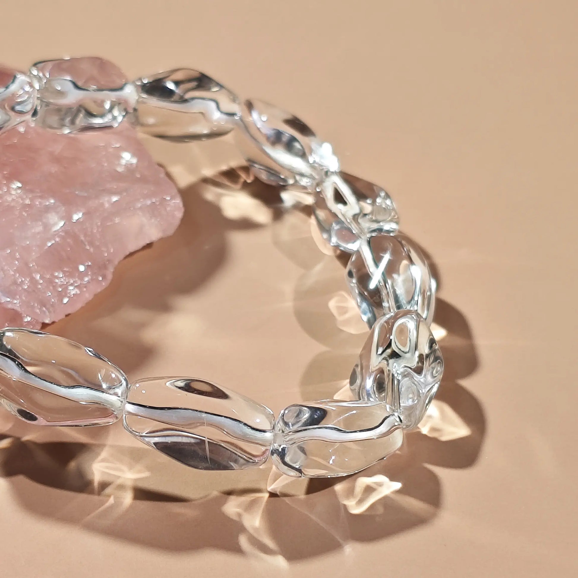 Clear quartz irregular beads arranged in infinity loop—showcasing translucency and organic contours under soft light